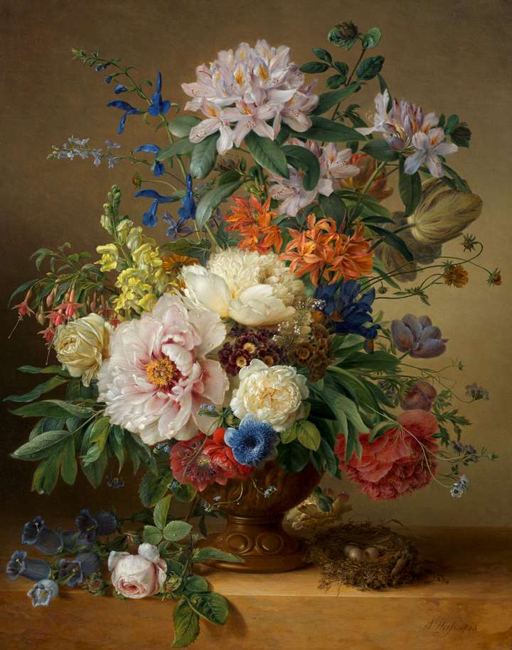 A peony, rhododendron, azalea, antirrhinum and larkspur in a sculpted urn on a stone ledge with a bird’s nest